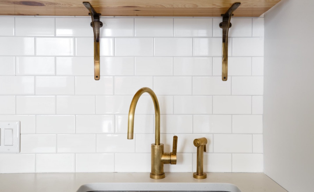 close-up of kitchen fixtures with white tile backsplash