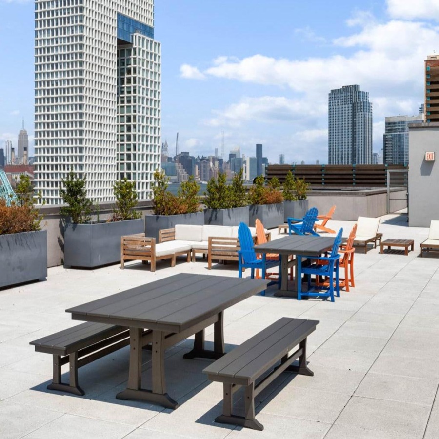 a patio with tables and chairs and a city skyline in the background