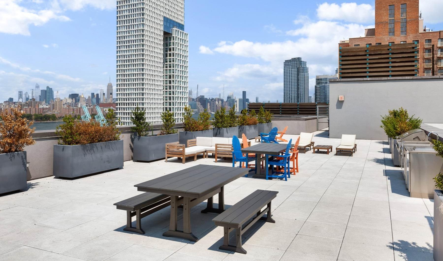 a patio with tables and chairs and a city skyline in the background